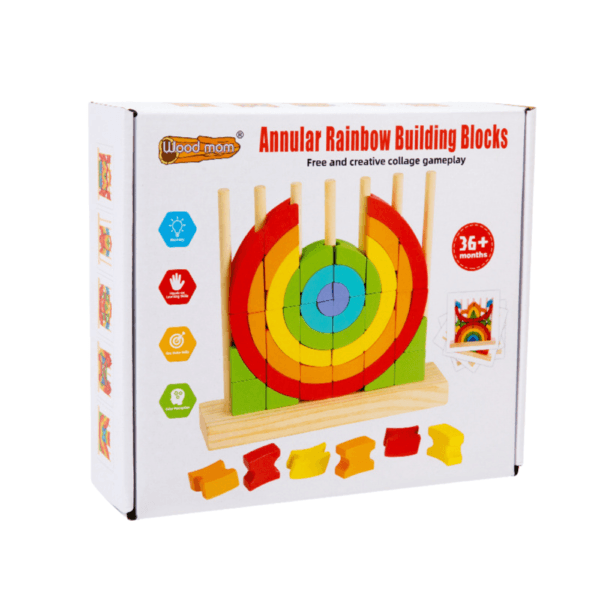 Blocs de construction jeu éducatif pour enfants "Wood mom Annular Rainbow Building Blocks". La boîte blanche et colorée montre le jouet assemblé : des anneaux en bois aux couleurs de l'arc-en-ciel empilés sur une base en bois avec des chevilles. Le produit est destiné aux 36 mois et plus et met en avant le développement de la mémoire, de la motricité fine et de la logique des couleurs.