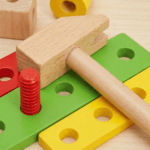 صورة مقربة للبراغي والصواميل الخشبية الملونة، المصممة لتطوير المهارات الحركية الدقيقة.