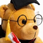 peluche ours diplômé avec chapeau de diplômé noir à gland jaune, lunettes rondes noires et écharpe noire et rouge, cadeau de remise de diplôme, disponible sur BrefShop.ma