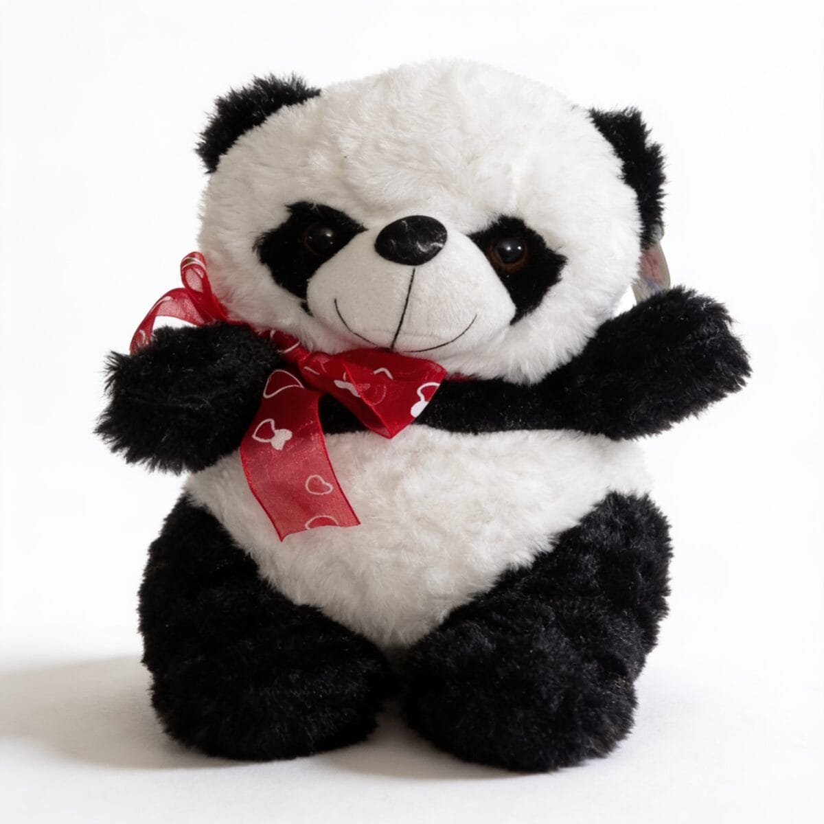 peluche panda en forme de panda avec nœud rouge motifs de cœurs et yeux et nez noirs, peluche décorative et affective, disponible sur BrefShop.ma